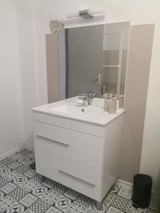 a white bathroom with a sink and a mirror at Chez Alex et Sophie in Louzac - Saint-André