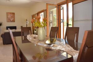 a dining room table with a vase with flowers on it at Sea View Two Bedroom Villa Giorgios in Gavalochori