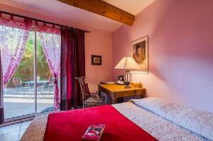 1 dormitorio con cama, escritorio y ventana en La Bastide des Pins, en Castillon-du-Gard