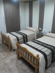 Habitación con 3 camas en una habitación en Hostal El Duende Blanco, en Sierra Nevada