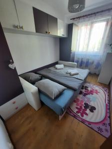 Habitación pequeña con cama y alfombra. en Happy apartament, en Sibiu