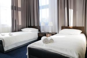 2 łóżka w pokoju hotelowym z białą pościelą w obiekcie Baza Hotelowa Bobrowiecka 9 w Warszawie