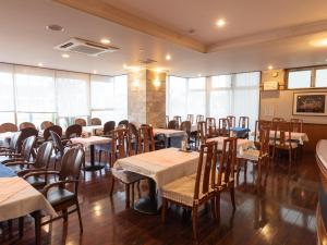 津市的住宿－Hotel Castle Inn Tsu，用餐室设有桌椅和窗户。
