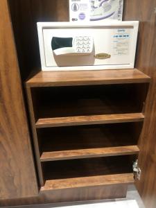 a microwave oven sitting on top of wooden shelves at Flat encantador com piscina e área de lazer in Brasília