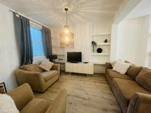 ein Wohnzimmer mit einem Sofa und einem TV in der Unterkunft Central 3-Bedroom Townhouse with Patio in Brighton in Brighton & Hove