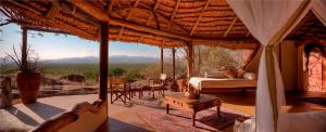 a room with a bed and a view of a field at Elewana Elsa's Kopje in Meru