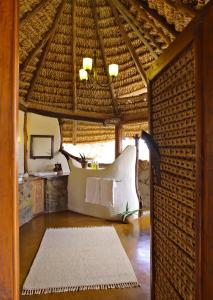 a room with a bed and a table in a building at Elewana Elsa's Kopje in Meru