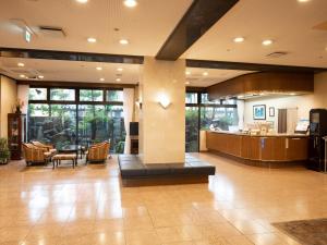 een lobby met een grote lobby met een tafel bij Hotel Castle Inn Suzuka in Suzuka