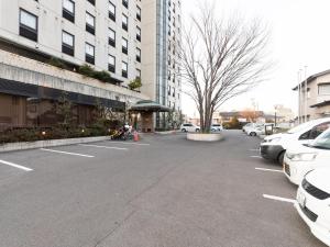 a parking lot with cars parked in front of a building at Hotel Castle Inn Suzuka in Suzuka