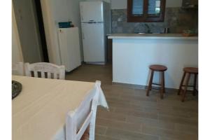 eine Küche mit einem Tisch und einem weißen Kühlschrank in der Unterkunft Μaria's house 1 in Edipsos