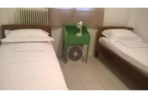um pequeno quarto com duas camas e uma mesa de cabeceira verde em Μaria's house 1 em Edipsos