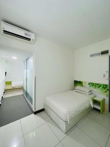 ein weißes Schlafzimmer mit einem Bett und einem Kühlschrank in der Unterkunft Green Apple Boutique Hotel in Kota Kinabalu