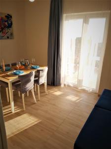 een eetkamer met een tafel en stoelen en een raam bij Apartman Helena in Gradac +12 foto's