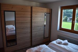 a bedroom with two beds and a large wooden cabinet at Apartement Karen TOP 35 - by Four Seasons Apartments in Kaprun