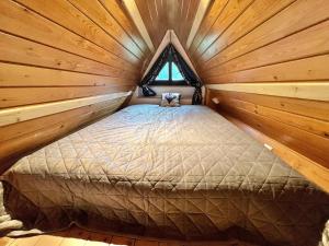 sypialnia w drewnianym domku z łóżkiem w obiekcie Tatrydom Apartament Loft z kominkiem w Zakopanem