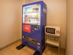 una máquina de soda azul con un microondas al lado en Hotel Castle Inn Suzuka Chuo en Suzuka