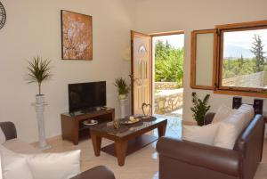 a living room with a couch and a tv at Sea View Two Bedroom Villa Giorgios in Gavalochori