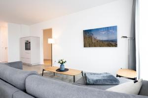 Sala de estar con sofá gris y mesa en Düne und Meer 7, en Dahme