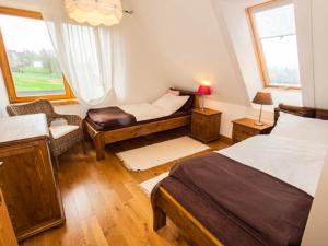 グリツァルフにあるApartament w Osadzie Podhalańskiejのベッドルーム1室(ベッド2台、椅子、窓付)