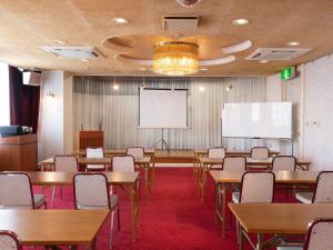 een klaslokaal met tafels en stoelen en een projectiescherm bij Hotel Castle Inn Yokkaichi in Yokkaichi