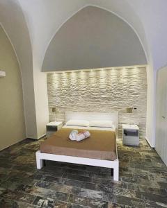 una camera con letto e parete in pietra di Appartamento Luxury a Massafra