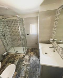 a bathroom with a shower and a sink and a toilet at Appartamento Luxury in Massafra +5 photos
