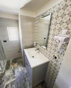 bagno con lavandino e specchio di Appartamento Luxury a Massafra