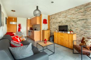 ein Wohnzimmer mit einem Sofa und einer Küche in der Unterkunft Panoram'Alp in Savièse