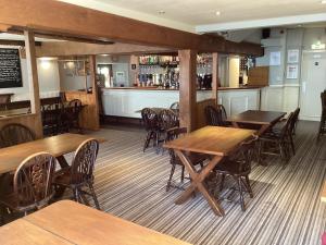 The Silverton Inn في Silverton: مطعم بطاولات وكراسي خشبية وبار