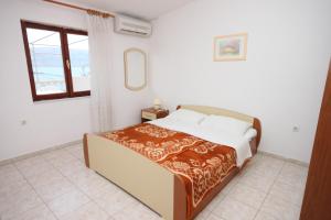 sypialnia z łóżkiem i oknem w obiekcie Apartments by the sea Metajna, Pag - 6352 w mieście Metajna