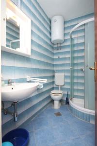 a blue bathroom with a sink and a toilet at Apartments by the sea Petrcane, Zadar - 6269 in Petrcane