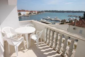 a balcony with a table and chairs and a view of the water at Apartments by the sea Petrcane, Zadar - 6269 in Petrcane