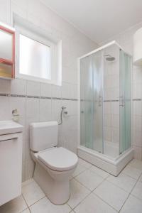 a bathroom with a toilet and a glass shower at Apartments by the sea Pirovac, Sibenik - 6280 in Pirovac