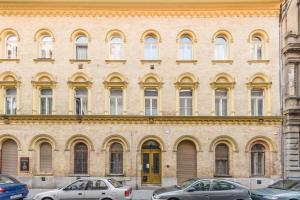 ein großes Backsteingebäude mit davor geparkt in der Unterkunft Venus Apartments - Almassy Park in Budapest
