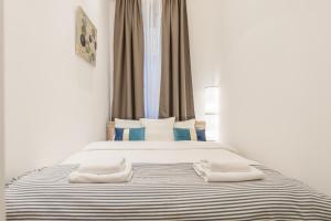 ein Schlafzimmer mit 2 Betten und Handtüchern darauf in der Unterkunft Venus Apartments - Almassy Park in Budapest