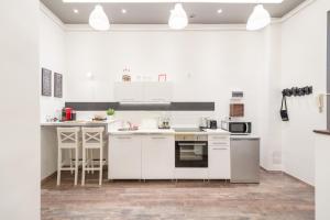 eine weiße Küche mit weißen Schränken und Geräten in der Unterkunft Venus Apartments - Almassy Park in Budapest