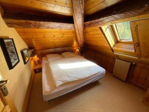an attic room with a bed in a log cabin at Le REFUGE véritable cocon avec Cheminée in Les Orres