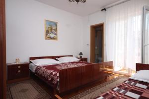 a bedroom with a large bed and a window at Rooms by the sea Metajna, Pag - 6378 in Metajna