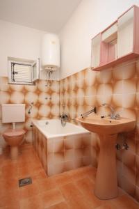 a bathroom with a sink and a tub and a toilet at Rooms by the sea Metajna, Pag - 6378 in Metajna