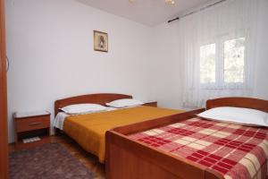a bedroom with two beds and a window at Rooms by the sea Metajna, Pag - 6378 in Metajna