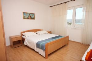 una camera con letto e finestra di Apartments by the sea Kustici, Pag - 6355 a Kustići
