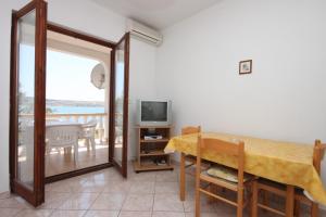 Apartments by the sea Kustici, Pag - 6355 في كوستيتشي: غرفة طعام مع طاولة وتلفزيون