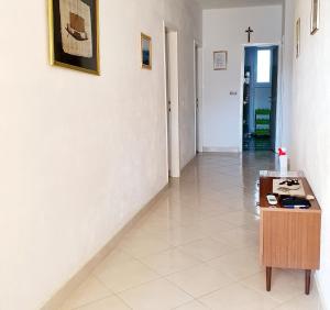 um corredor com uma mesa e uma cruz na parede em Apartments with a parking space Metajna, Pag - 6423 em Metajna