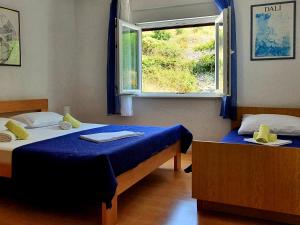 um quarto com duas camas e uma janela em Apartments with a parking space Metajna, Pag - 6423 em Metajna