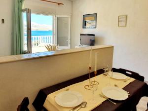 uma sala de jantar com uma mesa e vista para o oceano em Apartments with a parking space Metajna, Pag - 6423 em Metajna