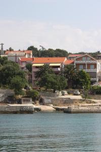 a group of buildings next to a body of water at Apartments by the sea Jakisnica, Pag - 6424 in Lun