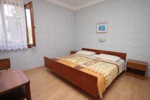 a bedroom with a bed and a table and a window at Apartments by the sea Jakisnica, Pag - 6424 in Lun