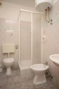 a bathroom with a toilet and a shower and a sink at Apartments by the sea Jakisnica, Pag - 6424 in Lun