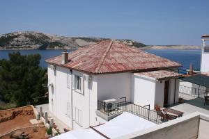 a white house with a view of the water at Apartments and rooms by the sea Stara Novalja, Pag - 6303 in Novalja