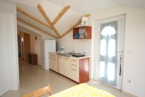 a kitchen with a white refrigerator and a table at Apartments with a parking space Mandre, Pag - 6415 in Kolan